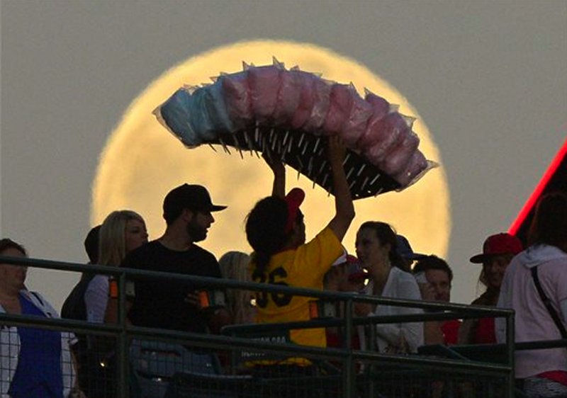 A cotton candy vendor, center, walks in from of the moon during the Los Angeles Angels' baseball game against the Pittsburgh Pirates, Saturday, June 22, 2013, in Anaheim, Calif.