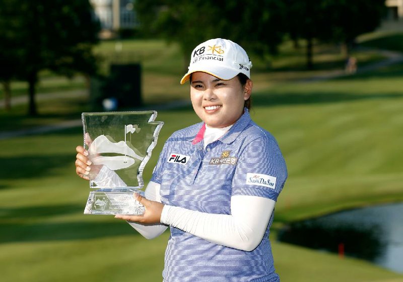 Inbee Park holds the Wal-Mart Northwest Arkansas Championship trophy Sunday afternoon at Pinnacle Country Club in Rogers after winning a playoff against fellow South Korean So Yeon Ryu. Park, the No. 1 player in the world, won her fifth tournament of the year. 