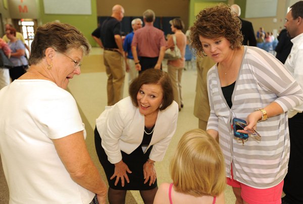 Janie Darr, superintendent of Rogers Public Schools, center, smiles as she greets incoming second-grader Madeline Secker, 7, as her mother, Lottie Secker of Rogers, right, and her grandmother, Vickie Forrest of Bella Vista, listen before the start of a dedication ceremony Sunday for Janie Darr Elementary School, 6505 Mount Hebron Road in Rogers. 