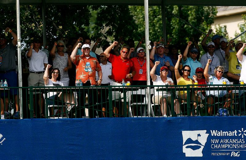 Fans call the Hogs from the stands near the 17th green as former Arkansas Razorback Stacy Lewis makes her approach during Friday’s first round of the Wal-Mart Northwest Arkansas Championship at Pinnacle Country Club in Rogers. 