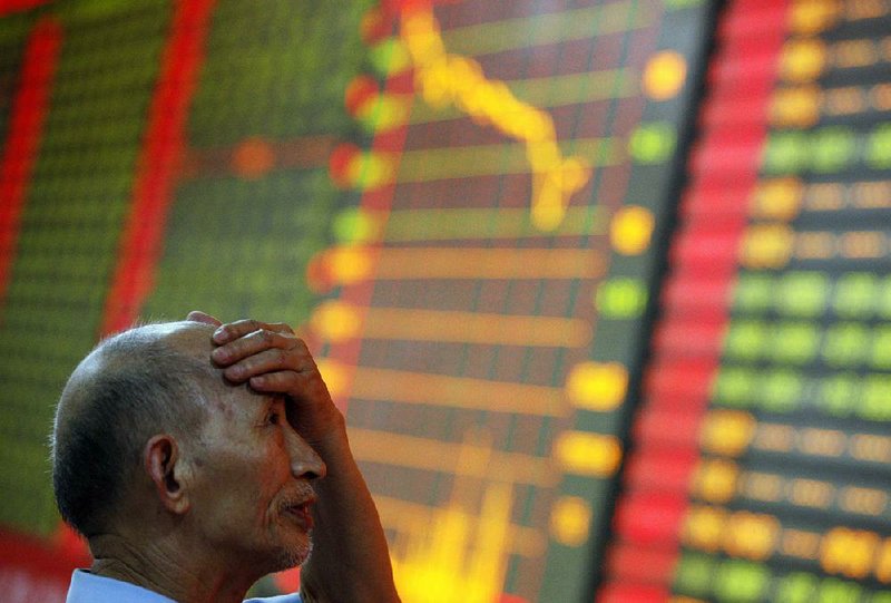 An investor watches a board displaying stock prices Monday at a brokerage house in Huaibei, China. 