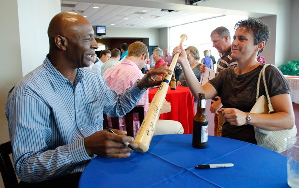 Willie Wilson, former Kansas City Royal, signs a baseball bat for Angela Hamberg, of Alton, Ill., Monday evening in Fayetteville. Wilson was the keynote speaker at the Texas League All-Star Gala. 