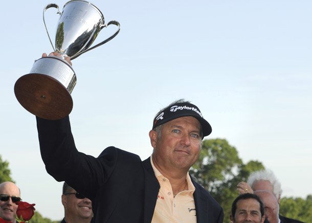 Ken Duke raises the trophy after winning the Travelers Championship golf tournament in Cromwell, Conn., Sunday, June 23, 2013. Duke won the tournament with a birdie on the second playoff hole. (AP Photo/Fred Beckham)