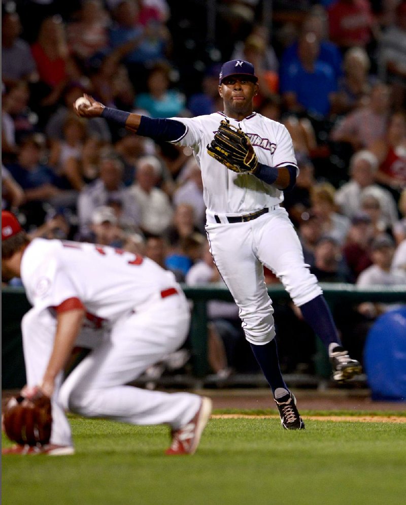 All-Star third baseman Rey Navarro of Northwest Arkansas (right) throws to first base in the eighth inning Tuesday night as Springfield pitcher Heath Wyatt avoids the throw. 