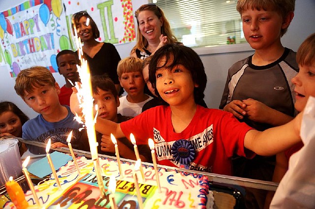 Joseph Buchmann takes in the glory of birthday candles (and sparklers!) on his ninth birthday June 15 at Shuffles & Ballet II in Little Rock. 