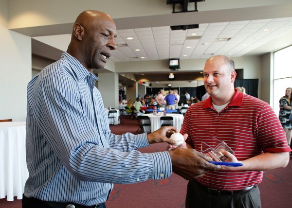 Willie Wilson, former Kansas City Royal, signs a baseball for John Owens of Little Rock on Monday in Fayetteville. Wilson was the keynote speaker at the Texas League All-Star Gala. 