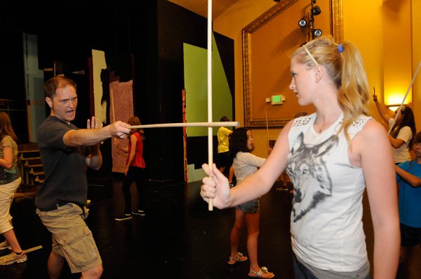 Fake, punches, kicks, eye-ball pokes and sword-fighting were among the techniques instructor Kris Pruett, left, taught theater campers including Haven Kirkpatrick, right, on Tuesday at the Rogers Little Theater. 