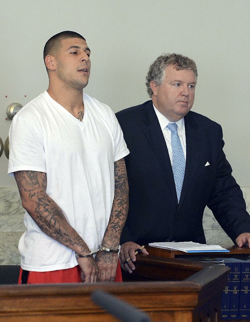 Former New England tight end Aaron Hernandez (left) stands with attorney Michael Fee during arraignment on murder charges in Attleboro (Mass.) District Court on Wednesday. 