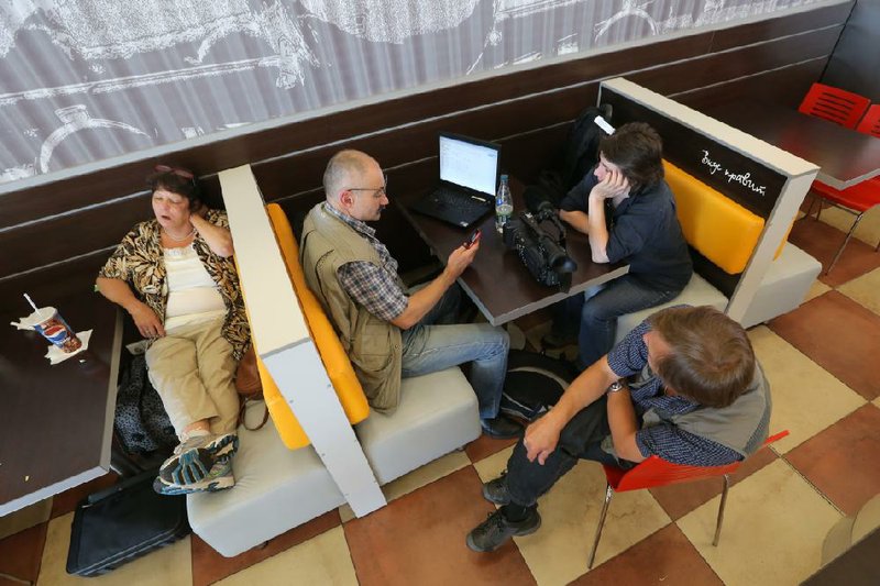 Journalists pass the time Wednesday in Moscow’s main airport as they and others wait for a glimpse of National Security Agency leaker Edward Snowden. Russian officials declined to comment on Snowden’s whereabouts a day after President Vladimir Putin said Snowden was in the airport. 