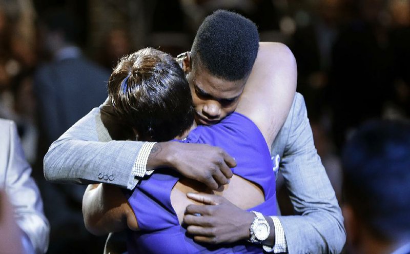 Kentucky’s Nerlens Noel gets a hug after he was drafted by the New Orleans Pelicans in the first round of the NBA Draft on Thursday in New York. He was then traded to Philadelphia. 