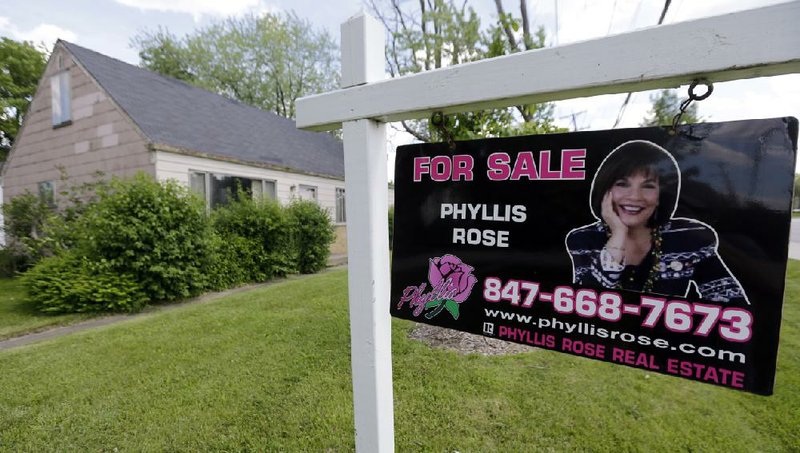 A for-sale sign stands in the yard of a home in Glenview, Ill. Average U.S. rates on 30-year fixed mortgages surged this week to the highest levels in two years, the biggest one-week increase in 26 years. 