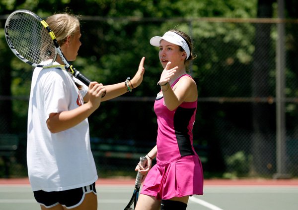 Doubles partners Emily Gean, 14, left, and Cara Stine, 15, both of Bentonville, celebrate a point Thursday while playing in the Cancer Challenge at the Kingsdale Tennis Center in Bella Vista. The afternoon event featured an instructional clinic and juniors tennis tournament.