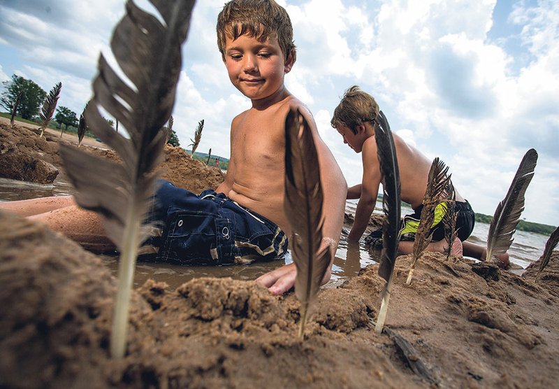 Carter Graham, 8, of Heber Springs, left, and his brother, Josh, 10, build a sand hot tub on the recently reopened Sandy Beach in Heber Springs.