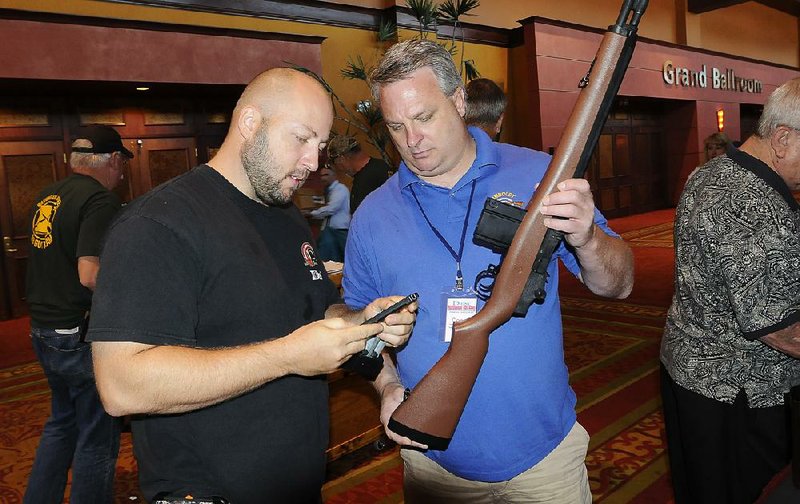 NWA MEDIA FLIP PUTTHOFF
Mike London, left, and Joe Krizan, both of South Dakota, look Thursday June 27 2013 over one of several air rifles on display at the 48th annual Daisy National BB Gun Championship Match being held at the John. Q. Hammons Center in Rogers. London is a parent of one of the shooters. Krizan is a shooting coach.