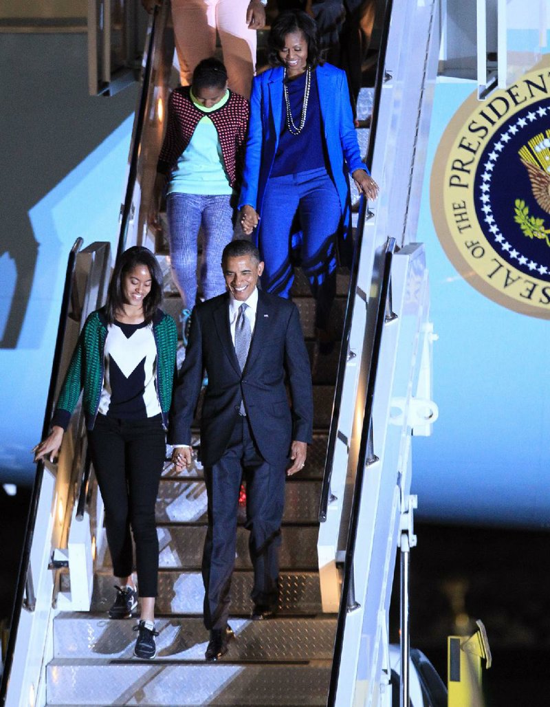 President Barack Obama, holding hands with daughter Sasha, and first lady Michelle Obama and eldest daughter Malia exit Air Force One at Waterkloof Airbase, Pretoria, Friday, June 28, 2013. President Obama is receiving the embrace you might expect for a long-lost son on his return to his father's home continent, even as he has yet to leave a lasting policy legacy for Africa on the scale of his two predecessors. (AP Photo/Themba Hadebe)