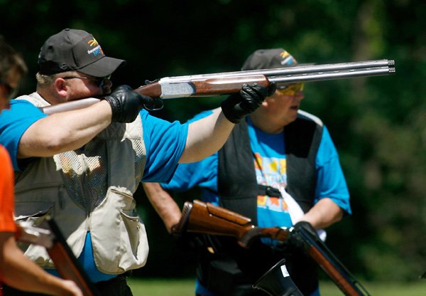 Russell Krah, left, and his father, Randy Krah, both of Taylorville, Ill., take aim Friday during the 20th annual Cancer Challenge trap shoot competition at the Highlands Gun Range in Bella Vista. 