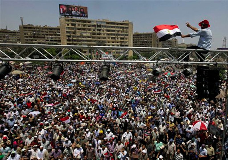 Supporters of Egypt's Islamist President Mohammed Morsi wave his posters and national flags as they fill a public square outside of the Rabia el-Adawiya Mosque in Cairo, not far from the presidential palace, during a rally in Cairo, Saturday, June 29, 2013. Thousands of supporters and opponents of Egypt's embattled Islamist president are holding rival sit-ins on the eve of what are expected to be massive opposition-led protests aimed at forcing Mohammed Morsi's ouster. The demonstrations early Saturday follow days of deadly clashes in a string of cities across the country that left at least seven people dead, including an American, and hundreds injured.