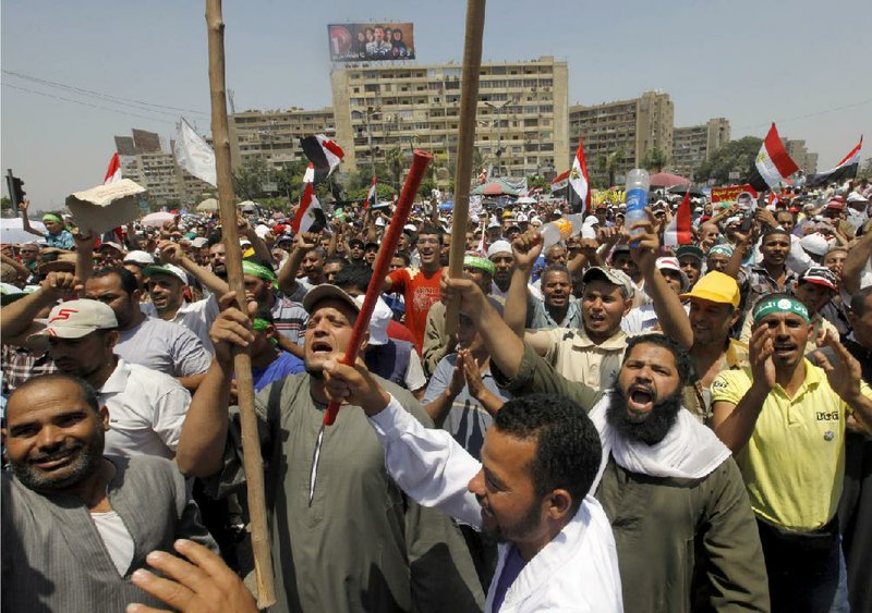 Club-wielding supporters of Egyptian President Mohammed Morsi rally outside a mosque in Cairo on Saturday as tempers flare on the eve of nationwide protests to demand Morsi’s resignation. 