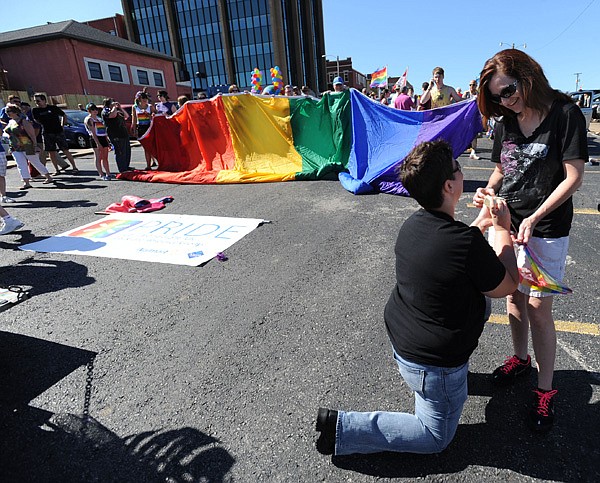 Kim Canaday, left, proposes Saturday to longtime girlfriend Karen Pollard, both of Gentry, before the start of the NWA Pride Parade in Fayetteville.