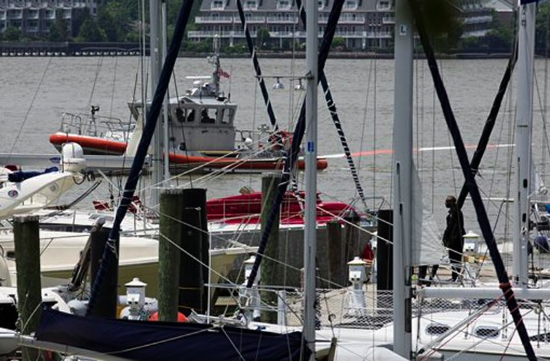 A helicopter rests on a pontoon at the 79th Street Boat Basin after emergency landing over the Hudson river, Sunday, June 30, 2013, in New York. New York authorities say a helicopter carrying four Swedish tourists has landed in the Hudson River off Manhattan, but everyone has been rescued. The incident happened shortly before noon Sunday in the section of the river near 79th Street. The pilot and four passengers were taken to shore.