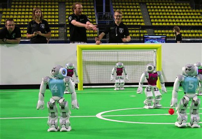 Robots in the "standard platform" division prepare for kickoff at a match held during the RoboCup championships in Eindhoven, Netherlands on Thursday, June 27, 2013. Around 300 teams from 40 countries are competing this week in the RoboCup championships. The competition has the long-term goal of building a team of androids good enough to beat the human world cup team by 2050. 