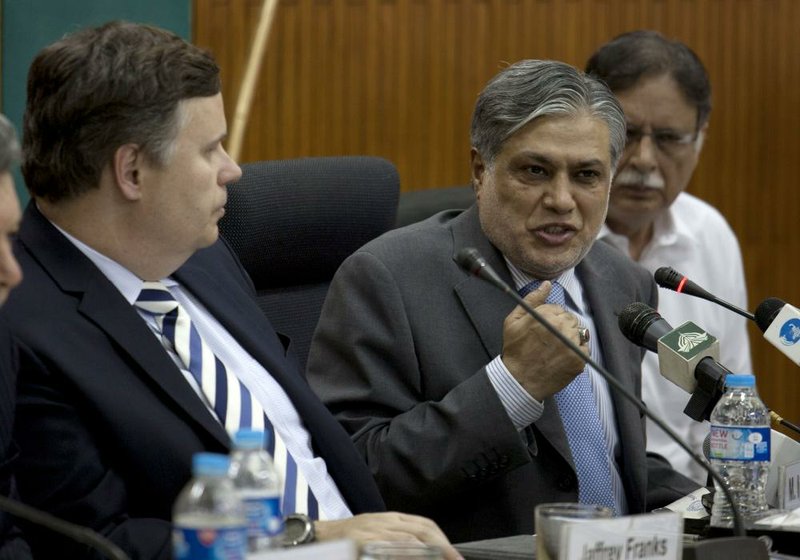 Pakistan Finance Minister Muhammad Ishaq Dar (center) speaks at a news conference with IMF mission chief Jeffrey Franks (left) on Thursday in Islamabad. 