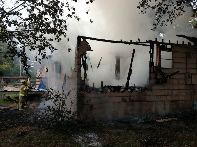 A house burns Friday, July 5, 2013, on Carrington Lane south of Little Rock.