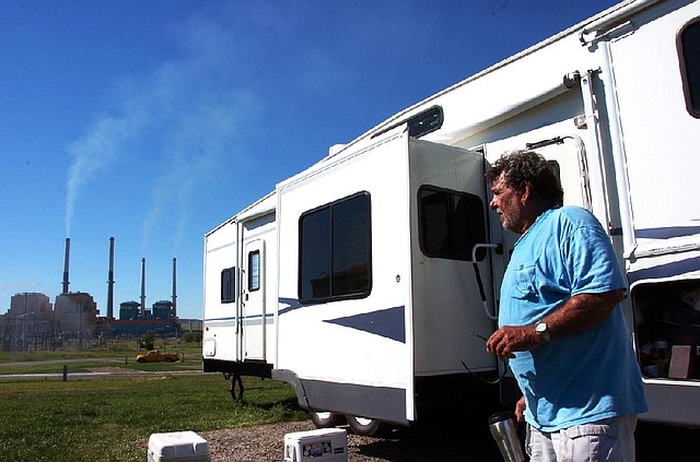 Joe Ashworth looks at smoke rising from the coal-fired Colstrip Steam Electric Station in Colstrip, Mont. as he takes a break from packing his RV on Tuesday. President Obama's climate change plan has people in the coal industry nervous about more coal plant closures, but supporters say retrofitting plants to capture greenhouse gases would create more jobs.  (AP Photo/Matthew Brown)