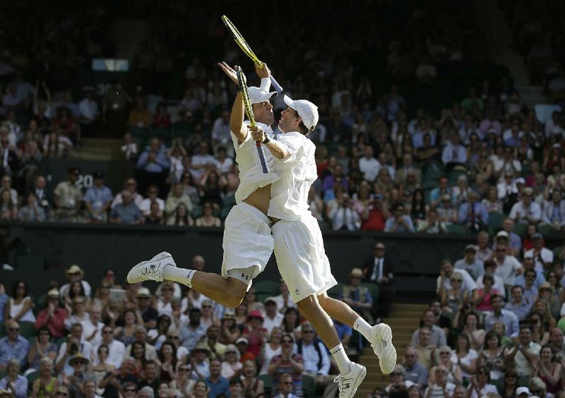 Bob Bryan and Mike Bryan of the United States celebrate after beating Ivan Dodig of Croatia and Brazil’s Marcelo Melo to win the men’s doubles final at Wimbledon in London on Saturday. The brothers now hold all four major men’s doubles titles. 