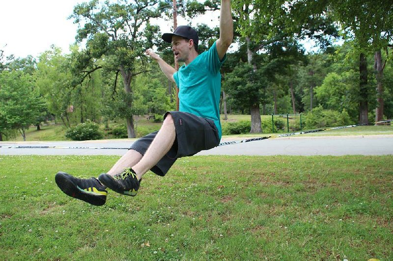 Daniel Carnahan enjoys bouncing up and down on a slackline he set up June 8 in Allsopp Park. Slacklining is gaining a following outside rock climbing circles as cyclists and runners have come to view it as a fun challenge for the body’s core muscles. 