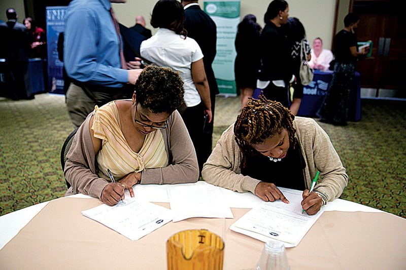 Job seekers fill out applications at the Choice Career Fairs job fair in Arlington, Va., in June. The number of job openings in the U.S. rose in May, the Labor Department said Tuesday. 