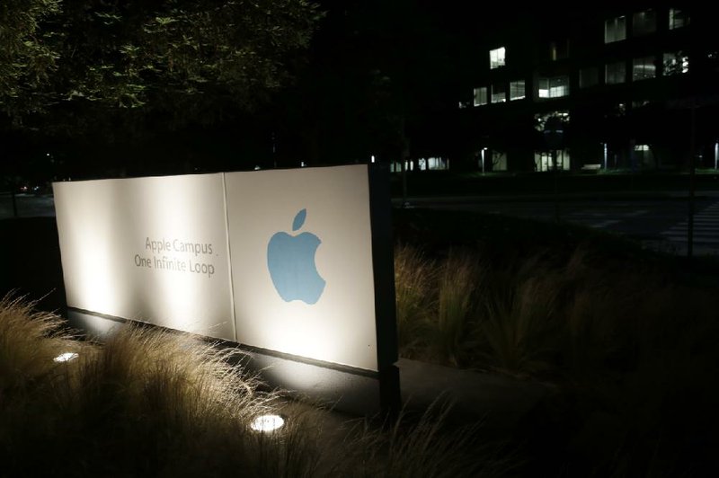 A sign displays the Apple logo outside of the company’s headquarters in Cupertino, Calif. Apple conspired with publishers to fix the prices of electronic books, a federal judge ruled Wednesday. 