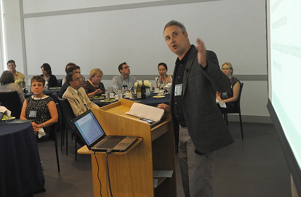 Brian Kisida with the University of Arkansas speaks Wednesday to attendees during dinner at Crystal Bridges Museum of American Art in Bentonville. Crystal Bridges is hosting a group of educators from art museums and art organizations for a three-day summit this week on the future of museum educational outreach. Officials from Los Angeles to New York City will brainstorm and share successes and failures in creating and implementing distance learning programs. 