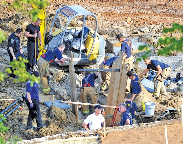 Fayetteville emergency responders work May 5 to free a construction worker trapped when a trench collapsed at The Vue, an apartment complex under construction in Fayetteville. 