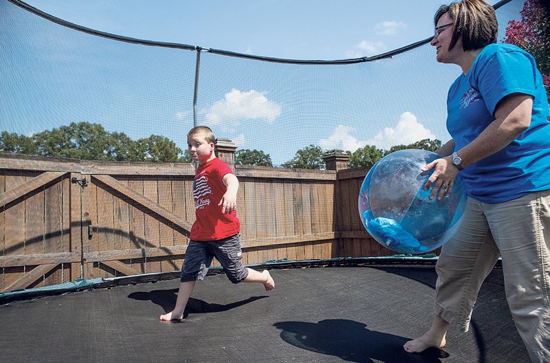Ben Huffmaster and his mother, Jody Huffmaster, play on a trampoline. Ben is one of only 170 people in the world with chromosome 18q deletion syndrome.