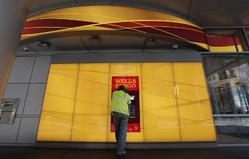 A customer uses an ATM outside a Wells Fargo branch in Charlotte, N.C., Tuesday, Jan. 17, 2012. WellsFargo & Co. reports their company earnings on Friday, July 12, 2013. (AP Photo/Chuck Burton)