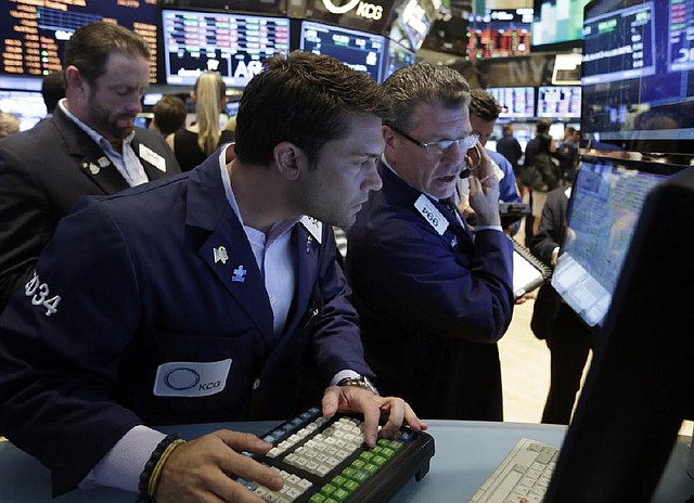 Specialist Joseph Dreyer, center, and trader Sean Spain, right, work on the floor of the New York Stock Exchange Friday, July 12, 2013. The U.S. stock market rally that led to record highs on Thursday has stalled. Major indexes were little changed in morning trading Friday. (AP Photo/Richard Drew)