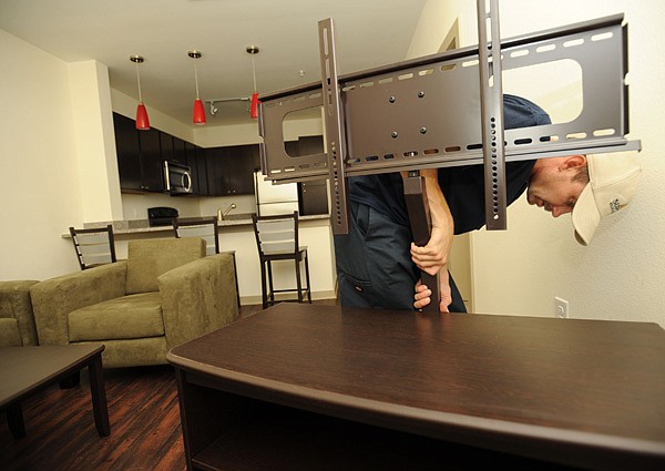 Jeff Norwood with Superior Relocation Service in Dallas works Friday to finish building an entertainment center at The Domain. 