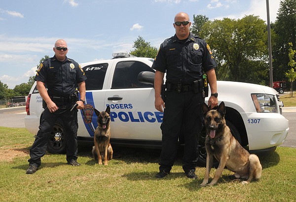 Rick Yager, left, Rogers police officer, and his police dog partner Dillon stand in front of their patrol SUV with fellow officers Roy Brooks and his police dog Kragen at the Rogers Police Department. The department recently got the two police dogs to join their staff. The department’s last police dog was retired about a year before these arrived. Kragen, one of the new dogs, found a loaded pistol, meth and pot during a traffic stop June 21, his first day on the job. 