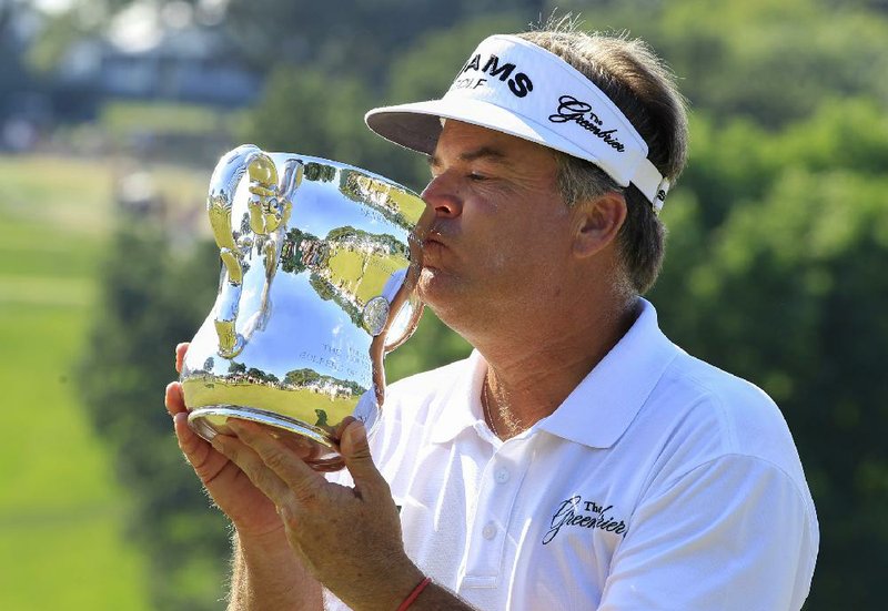 Kenny Perry kisses the trophy Sunday, July 14, 2013, after winning the U.S. Senior Open golf tournament in Omaha, Neb. (AP Photo/Nati Harnik)