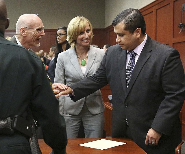 George Zimmerman (right) is congratulated by two members of his defense team, Don West and Lorna Truett, after hearing the verdict Saturday night in Sanford, Fla. 