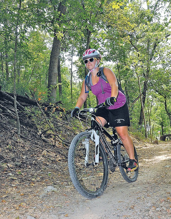 Courtney Walbe takes a spin Saturday along the Slaughter Pen Trail in Bentonville. The mountain bike and hiking trail features a network of loops from easy to difficult. 