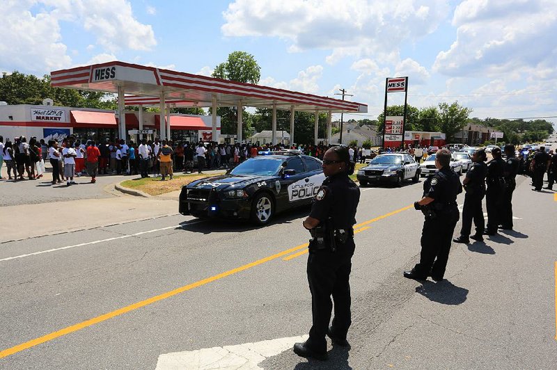 Arkansas Democrat-Gazette/RICK MCFARLAND --07/15/13--  Protesters gather at West 12th and Adams streets to voice their anger over the fatal shooting of a black male by a Little Rock Police officer Monday around 11:30 a.m. behind a home in the 1100 block of Adams St. The man ran from a stolen vehicle during a traffic stop on West 12th and Jefferson streets. He was chased into an alley and then a backyard where he was shot. The crowd of protesters grew and more officers were called in. The crowd was ordered to disperse and Rizelle Aaron, a civil rights' attorney, intervened and asked the protesters to go home. The police left the area and the crowd quieted.