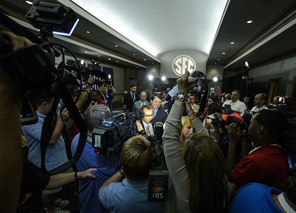 Florida Head Coach Will Muschamp moves from room to room through a throng of media during the SEC football Media Days in Hoover, Ala., Tuesday, July 16, 2013. (AP Photo/Alabama Media Group, Vasha Hunt)