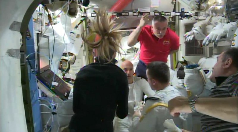 In this image from video made available by NASA, astronauts discuss the aborted spacewalk aboard the International Space Station on Tuesday, July 16, 2013. A dangerous water leak in the helmet of Luca Parmitano, bottom center facing camera in white suit, drenched his eyes, nose and mouth, preventing him from hearing or speaking as what should have been a routine spacewalk came to an abrupt end.
