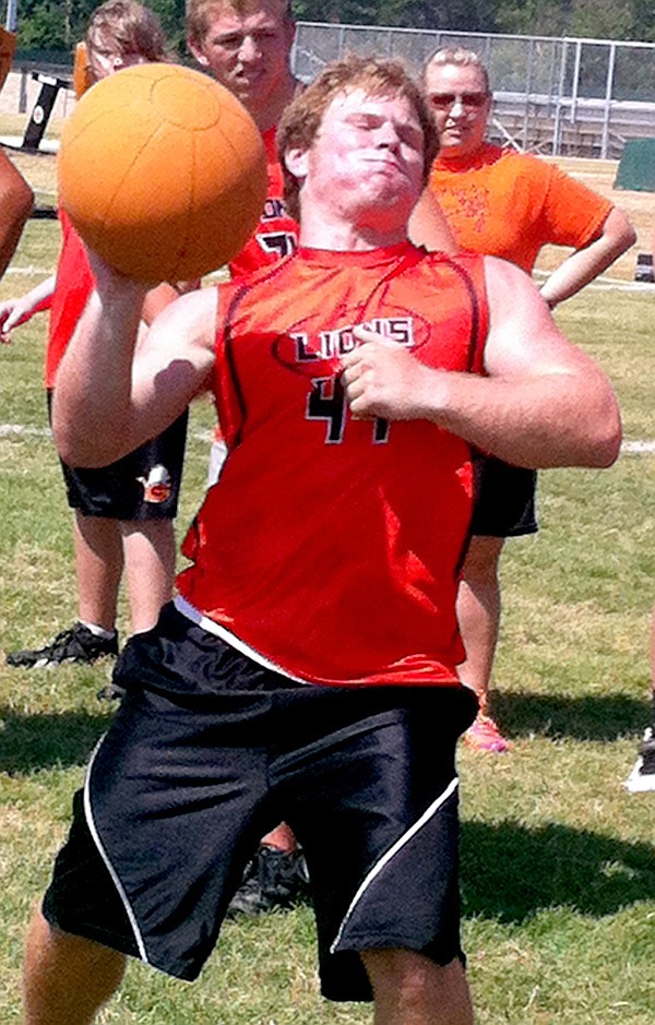 Gravette senior Cody Robinson throws a medicine ball during one of several events Friday during the 4-States Lineman Challenge at Gravette. Robinson helped the Gravette 2 team set event records in the medicine ball relay and the tire flip. 