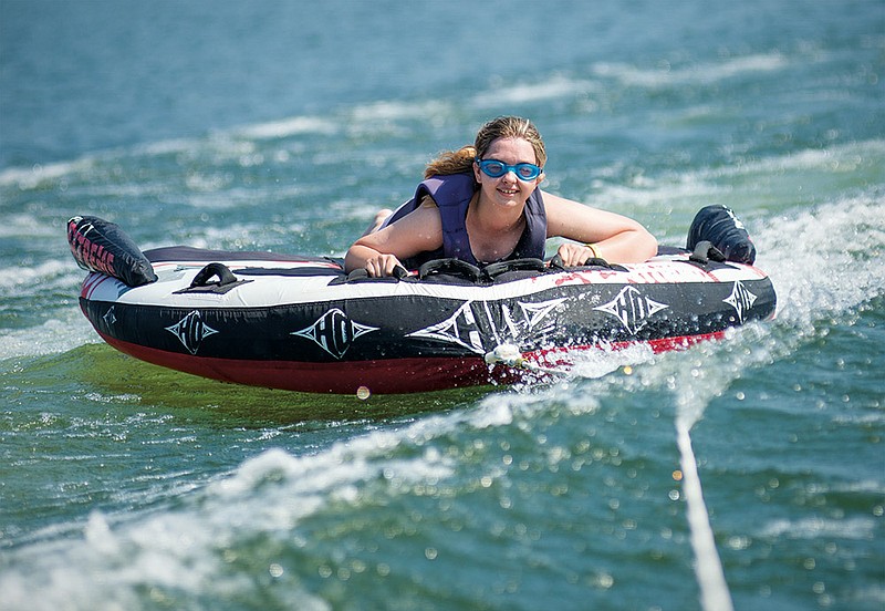 Maranda Young, 17, holds on tight while riding an inner tube on Lake Ouachita.
