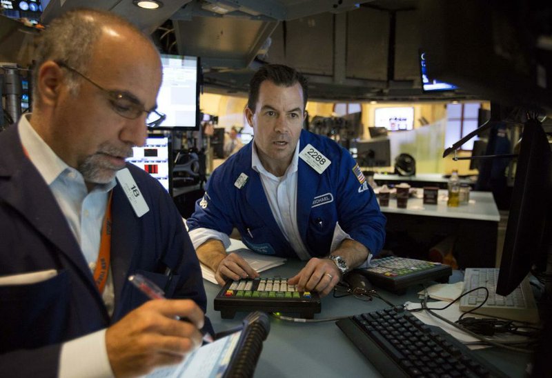 Traders work on the floor of the New York Stock Exchange where technology stocks fell Friday, holding the Standard & Poor’s 500 to a gain of 2.72 points. 