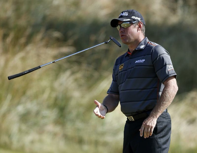 Lee Westwood of England, one of four players tied one shot behind leader Miguel Angel Jimenez, tosses his putter on the third green during the second round of the British Open at Muirÿeld. Westwood is trying to become the first Briton to win the tournament since Nick Faldo in 1992. 
