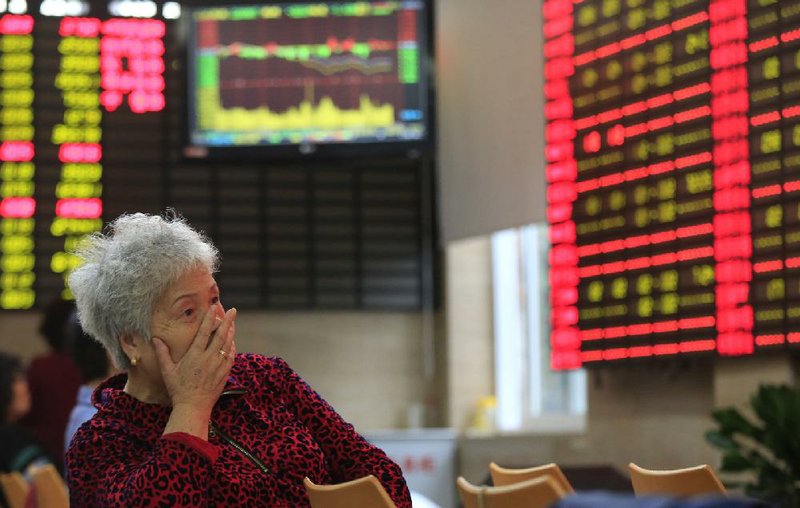 An investor examines changes on a stock-price monitor Friday at a private securities company in Shanghai. The Chinese government announced plans Friday to end controls on bank lending rates. 